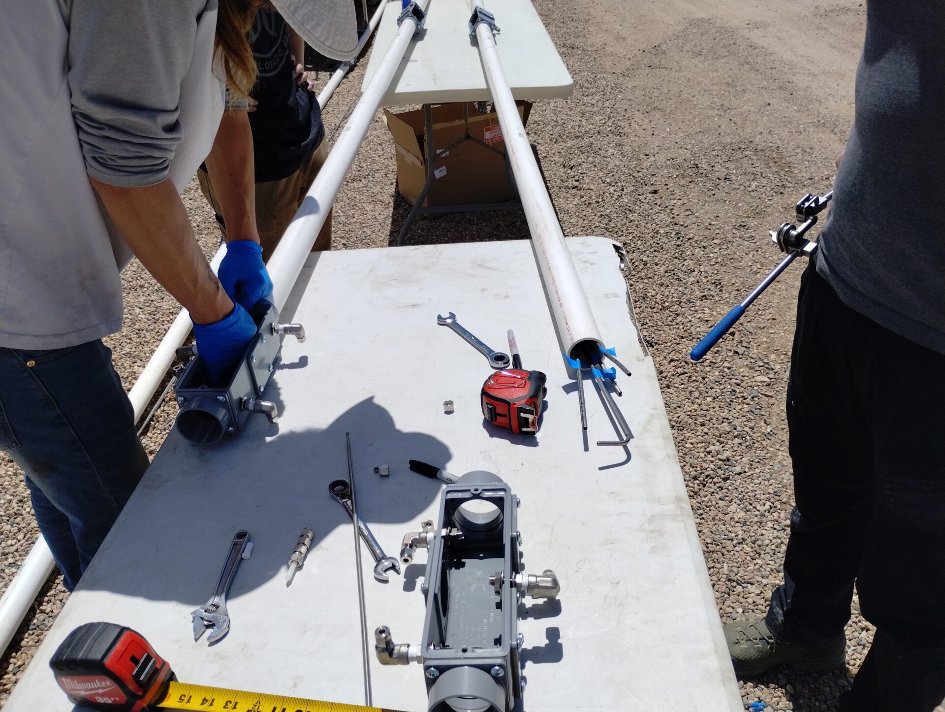 Research scientists installing gas release points on a section of pipe.